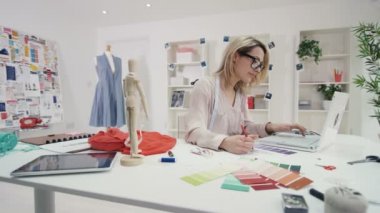 4k gülümseyen moda tasarımcısı yaratıcı stüdyo masasında çalışan portresi