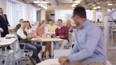 4k içinde yazıhane arka planda çalışan personel ile gülümseyen işadamı portresi
