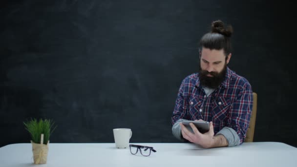 Smiling Hipster Man Met Behulp Van Computer Tablet Tegen Leeg — Stockvideo