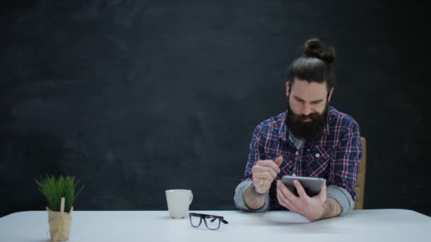 Συλλογισμένος Hipster Άνθρωπος Χρησιμοποιώντας Υπολογιστή Tablet Κενό Πίνακα Κιμωλίας Φόντο — Αρχείο Βίντεο