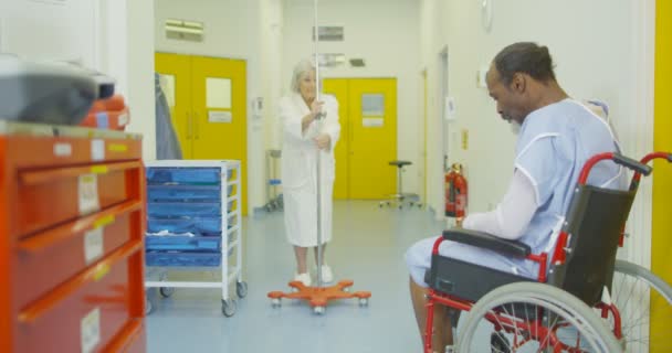 Sad Man Sits Alone His Wheelchair Busy Hospital Area — Stock Video