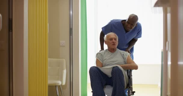 Travailleur Médical Soignant Poussant Homme Âgé Travers Hôpital Fauteuil Roulant — Video