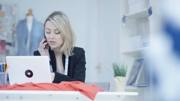 Dressmaker Своей Студии Работает Ноутбуке Разговаривает Телефону — стоковое видео