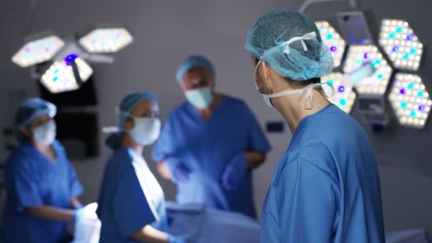 Porträt Eines Männlichen Chirurgen Operationssaal Mit Dahinterstehenden Kollegen — Stockvideo