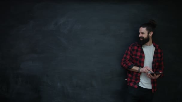 Smiling Hipster Man Using Tablet Looking Side Chalkboard — Stock Video