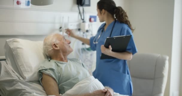 Cuidador Médico Hospital Hablando Con Anciano Lado Cama — Vídeo de stock