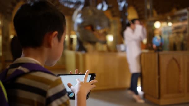 Маленький Мальчик Табличкой Музее Глядя Восхищением Динозавра — стоковое видео
