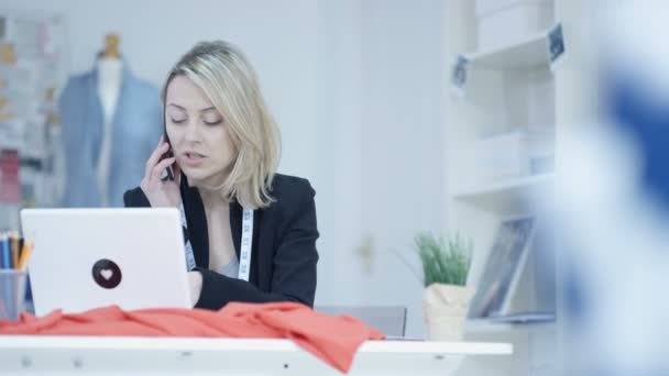 Dressmaker Estudio Trabajando Ordenador Portátil Hablando Por Teléfono — Vídeo de stock