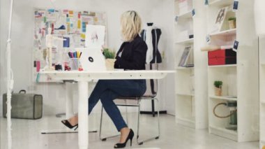 4 k moda dizüstü bilgisayarda çalışan ve çizimlere bakarak onun studio tasarımcısında,