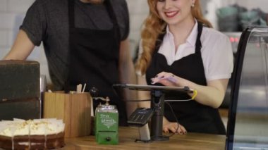 4k kafede tezgahın arkasındaki ayakta dostu gülümseyen işçi portresi