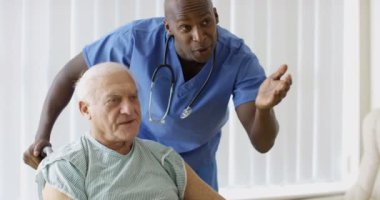 4 k bakım tıbbi çalışan yaşlı adam tekerlekli sandalye hastanede yoluyla bastırıyor