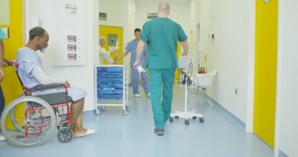 在现代医院内步行穿越繁忙地区的人员和病人 — 图库视频影像