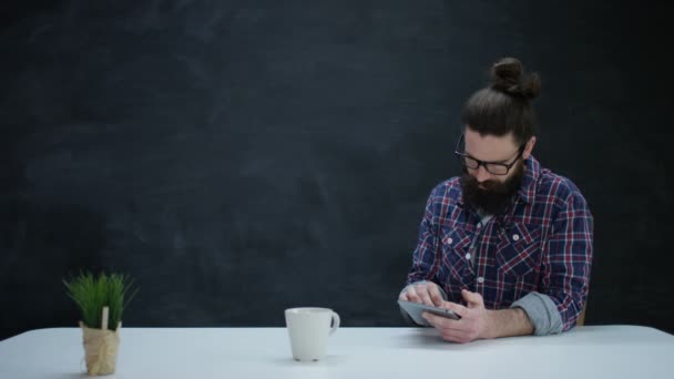 Hombre Hipster Pensativo Usando Tableta Computadora Sobre Fondo Pizarra Blanco — Vídeo de stock