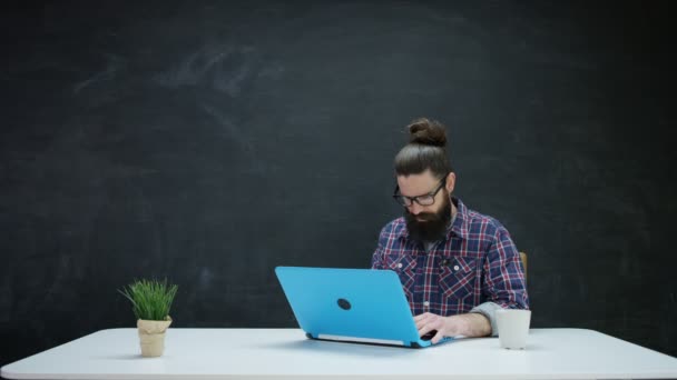 Man Работает Над Ноутбуком Ищет Вдохновение Фоне Доски — стоковое видео