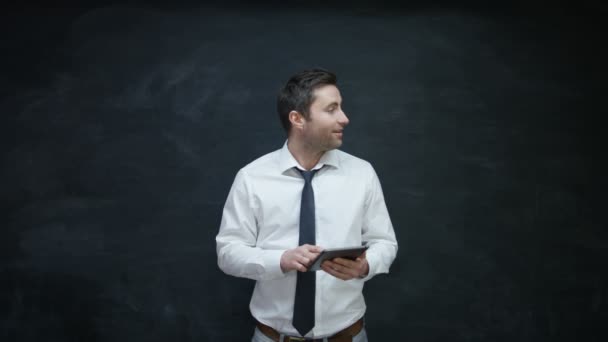 Smiling Businessman Using Tablet Looking Side Chalkboard — Stock Video