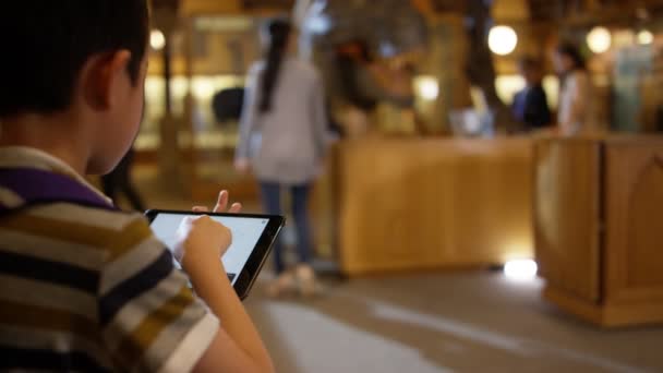 Menino Com Tablet Museu Olhando Com Fascínio Para Dinossauro — Vídeo de Stock