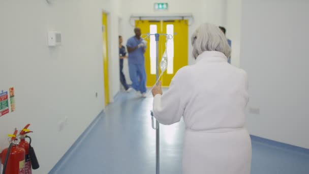 Персонал Пожилая Женщина Проходящие Через Оживленную Зону Здания Современной Больнице — стоковое видео