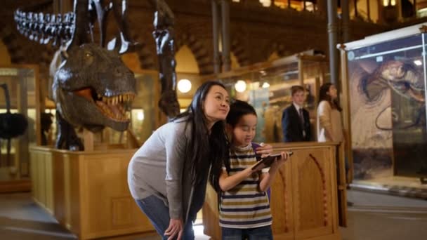 Mor Och Son Museum Stående Dinosaurieskelett Och Tittar Dator — Stockvideo