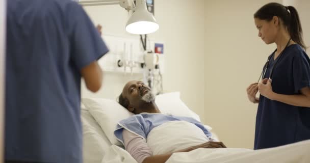 Cuidando Trabalhadores Médicos Hospital Conversando Com Homem Idoso Sua Cabeceira — Vídeo de Stock