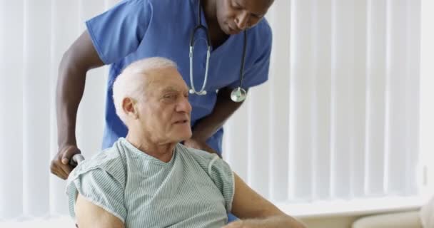Fürsorgliches Medizinisches Personal Schiebt Älteren Mann Rollstuhl Durch Krankenhaus — Stockvideo