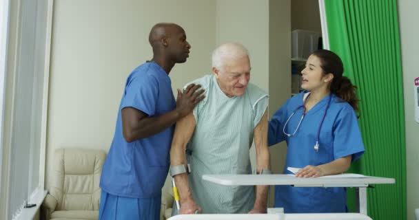 Φροντίδα Ιατρικού Προσωπικού Στο Νοσοκομείο Βοηθώντας Ηλικιωμένος Άνδρας Ένα Ιδιωτικό — Αρχείο Βίντεο