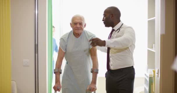 Bakım Tıbbi Işçi Koltuk Değneği Ile Yürüyen Yaşlı Adam Yardım — Stok video