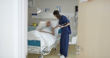 4 k bakım tıbbi çalışan yaşlı adama onun başucu konuşurken hastanede