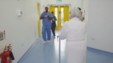 4 k personeli ve modern hastane binada meşgul alanı yürürken kadın kıdemli