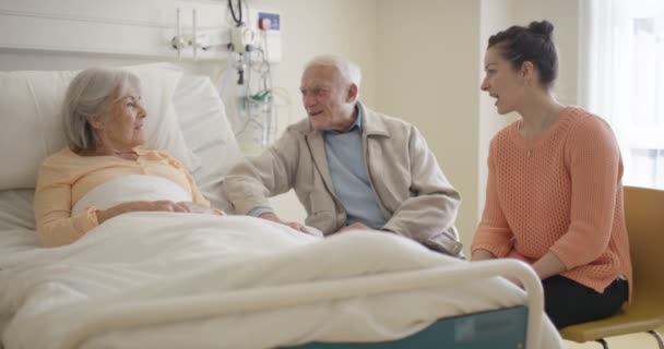 Senior Lady Hospital Room Marido Filha Visitando Conversando Com Ela — Vídeo de Stock
