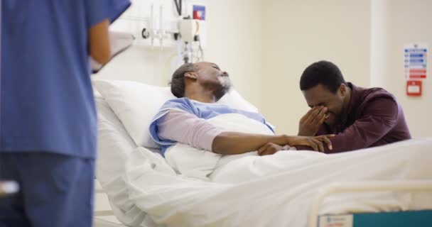 在父亲的床边 在医院和护士谈论他的病情时心烦意乱的男人 — 图库视频影像