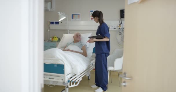 Cuidador Médico Hospital Hablando Con Anciano Lado Cama — Vídeo de stock