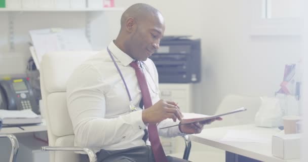 Porträt Eines Lächelnden Arztes Der Büro Sitzt Und Auf Patientenakten — Stockvideo