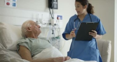 4 k bakım tıbbi çalışan yaşlı adama onun başucu konuşurken hastanede