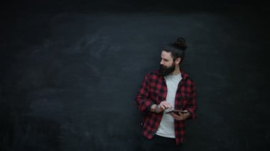 tablet kullanma, yan ve üstü seyir 4 k gülen hipster adam kara tahta üzerinde