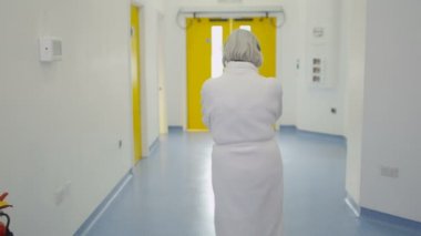 4 k personeli ve modern hastane binada meşgul alanı yürürken kadın kıdemli