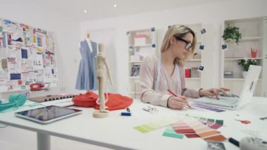 4k gülümseyen moda tasarımcısı yaratıcı stüdyo masasında çalışan portresi