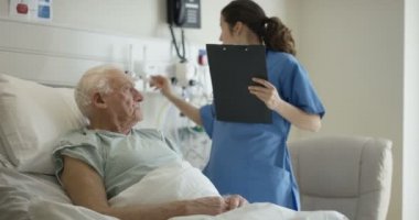 4 k bakım tıbbi çalışan yaşlı adama onun başucu konuşurken hastanede