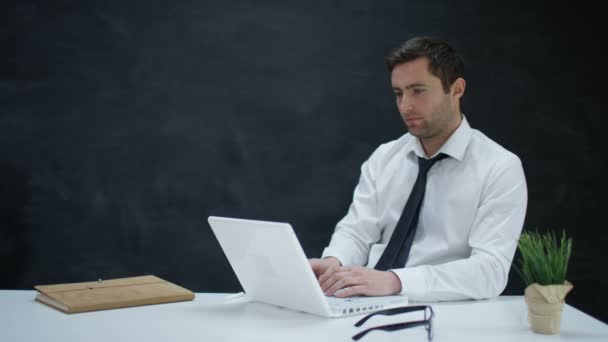 Nachdenklicher Geschäftsmann Arbeitet Laptop Mit Tafelhintergrund — Stockvideo