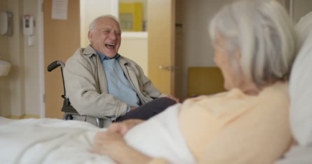 Szczęśliwa Para Starszy Szpitalnej Sali Człowiek Wózku Odwiedzając Chorych Żona — Wideo stockowe