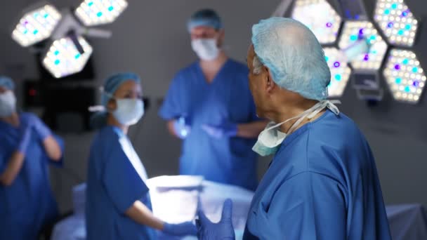 の後ろに立っている同僚と手術の男性外科医の肖像画 — ストック動画