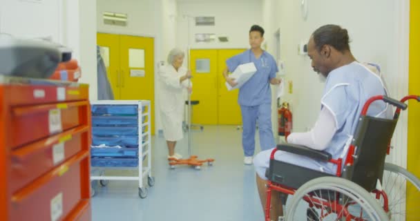 Sad Man Sits Alone His Wheelchair Busy Hospital Area — Stock Video