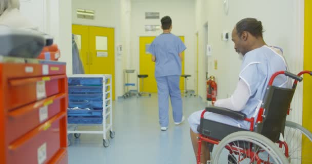 Triste Hombre Sienta Solo Silla Ruedas Ajetreada Zona Del Hospital — Vídeo de stock