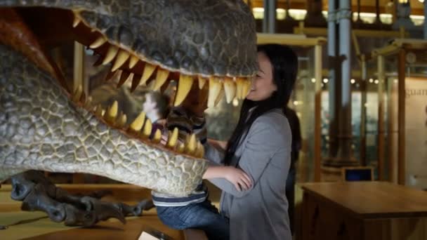 博物馆里的母亲和儿子正在研究重建的恐龙模型 — 图库视频影像