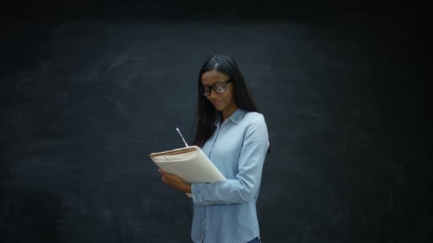 Porträt Einer Lächelnden Frau Die Notizbuch Auf Kreidetafel Hintergrund Schreibt — Stockvideo