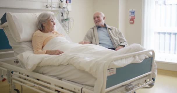 Pareja Mayor Habitación Del Hospital Hombre Visitando Esposa Enferma Charlando — Vídeo de stock