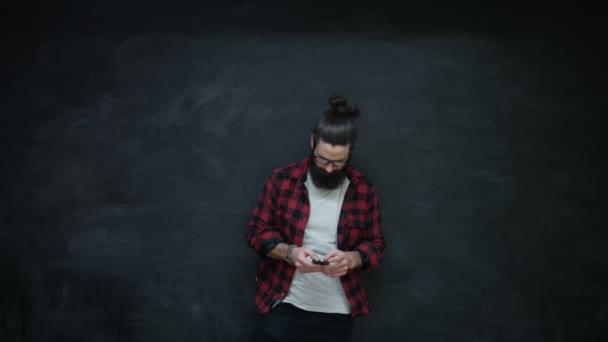 Hipster Hombre Utilizando Teléfono Inteligente Mirando Los Lados Con Sorpresa — Vídeos de Stock