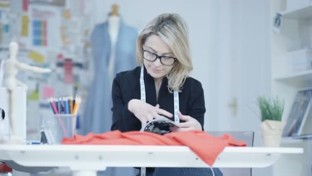 Dressmaker Dans Son Studio Regardant Magazine Pour Inspiration — Video