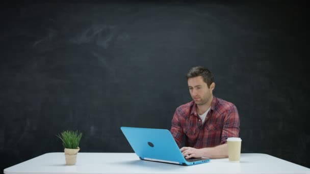 Man Работает Над Ноутбуком Ищет Вдохновение Фоне Доски — стоковое видео