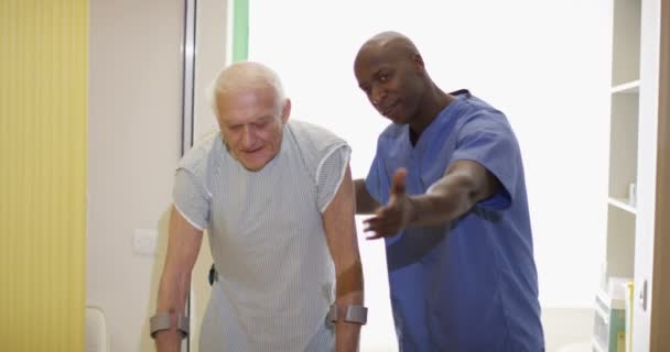 Cuidador Médico Que Ayuda Anciano Caminar Con Muletas — Vídeo de stock