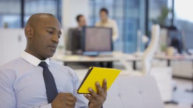 4k Ofis, belge üzerindeki getiren iş arkadaşınız tablet bilgisayar kullanarak Afrika kökenli Amerikalı iş adamı